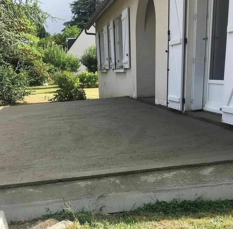 Chape de terrasse fraîchement tirée devant une maison, avant la pose du revêtement